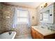 Cozy bathroom featuring floral wallpaper, claw foot tub, and vintage-style fixtures at 1400 Florida Ave, St Cloud, FL 34769