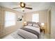 Bedroom with floral wallpaper, ceiling fan, and a bed with neutral bedding at 1400 Florida Ave, St Cloud, FL 34769