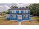 Front exterior of two-story home with a white front door, blue siding and black roof at 1400 Florida Ave, St Cloud, FL 34769