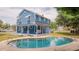 Exterior of house with pool, blue siding, white columns on porch, and second story porch at 1400 Florida Ave, St Cloud, FL 34769