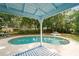 View of the in-ground swimming pool and jacuzzi, framed by blue back porch beams at 1400 Florida Ave, St Cloud, FL 34769