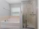 Bright bathroom featuring a bathtub, shower, and a large window at 1532 Angler Ave, Kissimmee, FL 34746