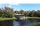 Picturesque view of a private covered dock on a serene pond surrounded by lush trees at 1532 Angler Ave, Kissimmee, FL 34746