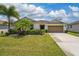 Charming single-story home with a lush, green lawn, mature landscaping, and a two-car garage at 1532 Angler Ave, Kissimmee, FL 34746