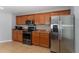 Kitchen boasts stainless steel appliances, granite countertops, and warm wood cabinetry at 1532 Angler Ave, Kissimmee, FL 34746