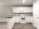 Well-lit kitchen featuring white appliances, white cabinetry, and stone-look countertops at 158 Violet Ct, Poinciana, FL 34759