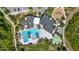 Aerial view of a community pool with lounge seating, playground, parking lot, and other community amenities and greenery at 17324 Bracken Fern Ln, Clermont, FL 34714