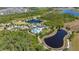 An aerial view of a community clubhouse, pool and recreation area, surrounded by lush landscaping, walking paths, and ponds at 17324 Bracken Fern Ln, Clermont, FL 34714
