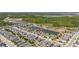 Aerial view showcases a neighborhood near a tranquil lake and lush greenery at 17324 Bracken Fern Ln, Clermont, FL 34714