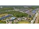 Aerial view of a planned community with a pool and amenity center, a pond, wooded areas and many homes at 17324 Bracken Fern Ln, Clermont, FL 34714