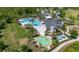 Beautiful aerial view of a community clubhouse with pools, splashpad, playground, parking, and green space at 17324 Bracken Fern Ln, Clermont, FL 34714
