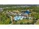 Aerial view of neighborhood clubhouse featuring a large swimming pool, playground and convenient parking, all nestled in lush landscaping at 17324 Bracken Fern Ln, Clermont, FL 34714