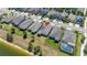 Aerial view of homes featuring backyard fences, lush lawns, and lake views at 17324 Bracken Fern Ln, Clermont, FL 34714