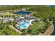 Aerial view showcases the community clubhouse featuring a resort-style pool, playground, surrounding lakes, and landscaped grounds at 17324 Bracken Fern Ln, Clermont, FL 34714