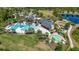 Aerial view of a community clubhouse featuring a swimming pool, splashpad, play area, green space, and convenient parking at 17324 Bracken Fern Ln, Clermont, FL 34714