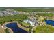 Aerial view of the community clubhouse featuring pool, splashpad,playground, green space, parking, and lakes at 17324 Bracken Fern Ln, Clermont, FL 34714