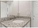 Well-lit bathroom featuring white cabinets, a granite countertop, and a large mirror over the sink at 17324 Bracken Fern Ln, Clermont, FL 34714