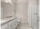 Well-lit bathroom with double vanity, granite countertop, and a glass-enclosed shower at 17324 Bracken Fern Ln, Clermont, FL 34714