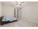 Neutral bedroom featuring tile floors, a ceiling fan, and a large window with decorative curtains at 17324 Bracken Fern Ln, Clermont, FL 34714