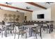 Well-appointed clubhouse interior with multiple tables and chairs, a TV, and modern decor under a beamed ceiling at 17324 Bracken Fern Ln, Clermont, FL 34714
