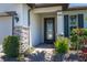 Elegant front entry with decorative glass door, stone accents, and manicured landscaping at 17324 Bracken Fern Ln, Clermont, FL 34714