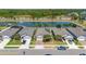 Front exterior of homes featuring a well-manicured lawn, 2-car garage, and serene lake view at 17324 Bracken Fern Ln, Clermont, FL 34714