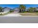 Well-maintained single-story home with a brick driveway, two-car garage, and lush green lawn at 17324 Bracken Fern Ln, Clermont, FL 34714