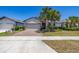 Inviting single-story home featuring a brick driveway, two-car garage, and well-manicured landscaping at 17324 Bracken Fern Ln, Clermont, FL 34714