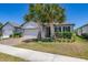 Attractive single-story home with a brick driveway, two-car garage, and beautiful palm trees at 17324 Bracken Fern Ln, Clermont, FL 34714