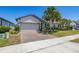 Lovely single-story home with a brick driveway, two-car garage, and manicured landscaping at 17324 Bracken Fern Ln, Clermont, FL 34714