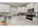 Close up of kitchen featuring stainless steel appliances, granite countertops, white cabinets and tiled backsplash at 17324 Bracken Fern Ln, Clermont, FL 34714