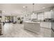 Open-concept kitchen with island leading into a living area with tile flooring and a sliding glass door to a patio at 17324 Bracken Fern Ln, Clermont, FL 34714
