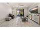 Living room featuring sliding glass doors to a patio, a decorative cabinet, a ceiling fan, and light grey tile floors at 17324 Bracken Fern Ln, Clermont, FL 34714