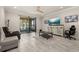 Living room with sliding glass doors to a patio, a decorative cabinet, ceiling fan, and tile floors at 17324 Bracken Fern Ln, Clermont, FL 34714