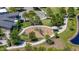 An aerial view of a neighborhood playground with modern equipment, soft ground cover, and a walking path next to the pond at 17324 Bracken Fern Ln, Clermont, FL 34714