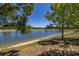 Peaceful view of the pond with sandy shoreline and trees, creating a tranquil setting at 17324 Bracken Fern Ln, Clermont, FL 34714
