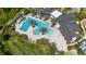 Aerial view of a beautiful community pool featuring palm trees, lounge chairs and a large pool for residents to enjoy at 17324 Bracken Fern Ln, Clermont, FL 34714
