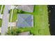 Aerial view of the home featuring lush green lawn, mature landscaping, and a community pond at 1976 The Oaks Blvd, Kissimmee, FL 34746