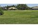Expansive lawn overlooking a golf course, complete with a sand trap and a view of neighboring homes at 1976 The Oaks Blvd, Kissimmee, FL 34746