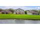 Backyard of home featuring deck, patio, and lush green lawn extending to a serene pond at 1976 The Oaks Blvd, Kissimmee, FL 34746