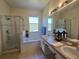 Bright bathroom with a soaking tub, glass-enclosed shower, and double sink vanity at 1976 The Oaks Blvd, Kissimmee, FL 34746
