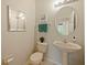 Bright bathroom with decorative mirror, pedestal sink, and tiled flooring at 1976 The Oaks Blvd, Kissimmee, FL 34746