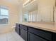 Bathroom featuring a single vanity, neutral tile floors, and a bright window offering natural light at 1976 The Oaks Blvd, Kissimmee, FL 34746