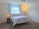 Bright bedroom featuring a queen bed, neutral carpet, and a window offering natural light at 1976 The Oaks Blvd, Kissimmee, FL 34746