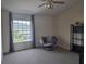 Cozy bedroom with a window, ceiling fan, accent chair, and shelving at 1976 The Oaks Blvd, Kissimmee, FL 34746