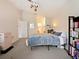 Bright bedroom featuring a double bed, gray carpeting and a view into the ensuite bathroom at 1976 The Oaks Blvd, Kissimmee, FL 34746
