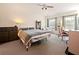Bedroom featuring a ceiling fan, two windows, gray carpet and furniture for work and rest at 1976 The Oaks Blvd, Kissimmee, FL 34746