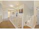 Bright second story hallway with an archway, white railings, and multiple rooms on either side at 1976 The Oaks Blvd, Kissimmee, FL 34746