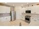 Bright kitchen features stainless steel appliances, white cabinetry, granite countertops, and tile flooring at 1976 The Oaks Blvd, Kissimmee, FL 34746