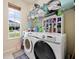 Functional laundry room with modern washer and dryer set, shelving, and natural light at 1976 The Oaks Blvd, Kissimmee, FL 34746